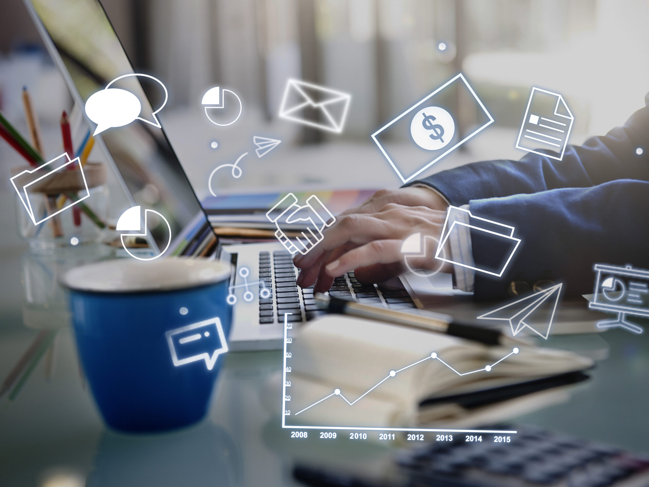 ノートPCで作業するビジネスマンと浮かぶデジタルアイコン群（チャット、メール、グラフなど）