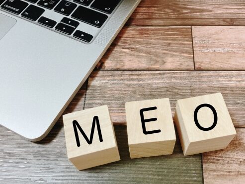 パソコンの横にMEOという積み木が並んでいる